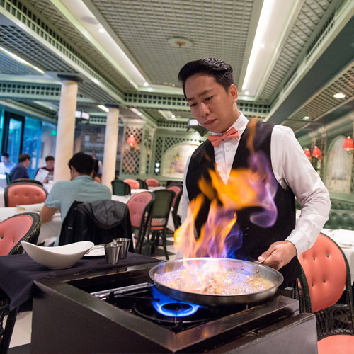 Brennan's waiter cooking some bananas foster tableside